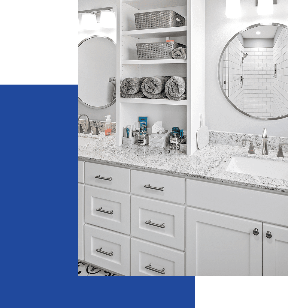 A bathroom with white cabinets and green walls.