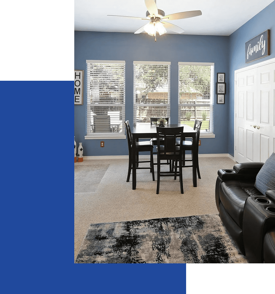 A living room with blue walls and black furniture.