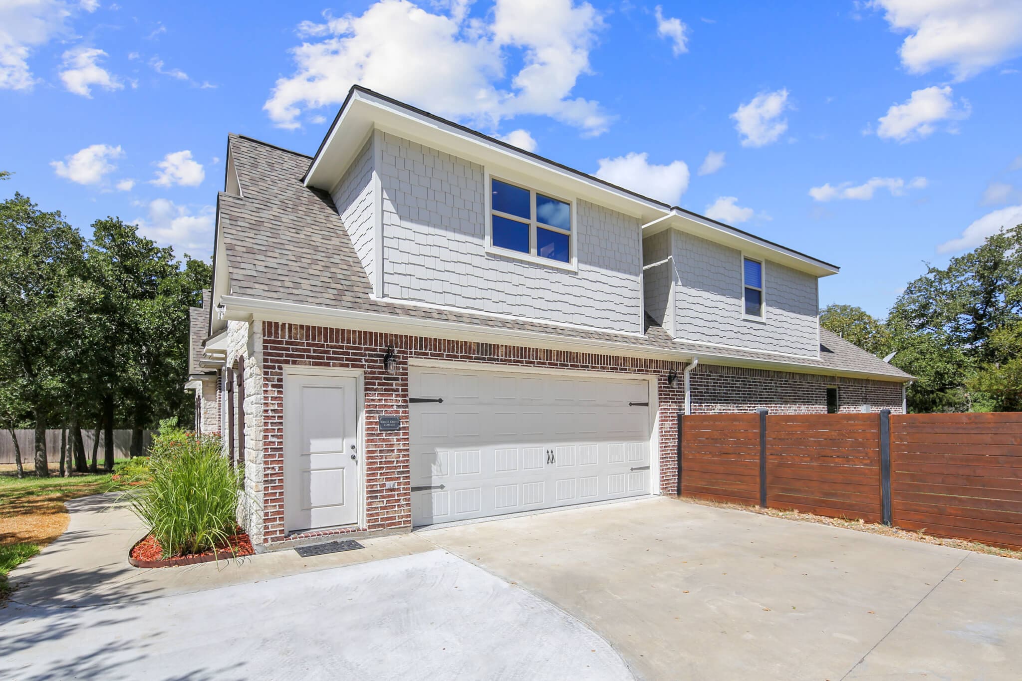 A large garage with two doors and a fence.