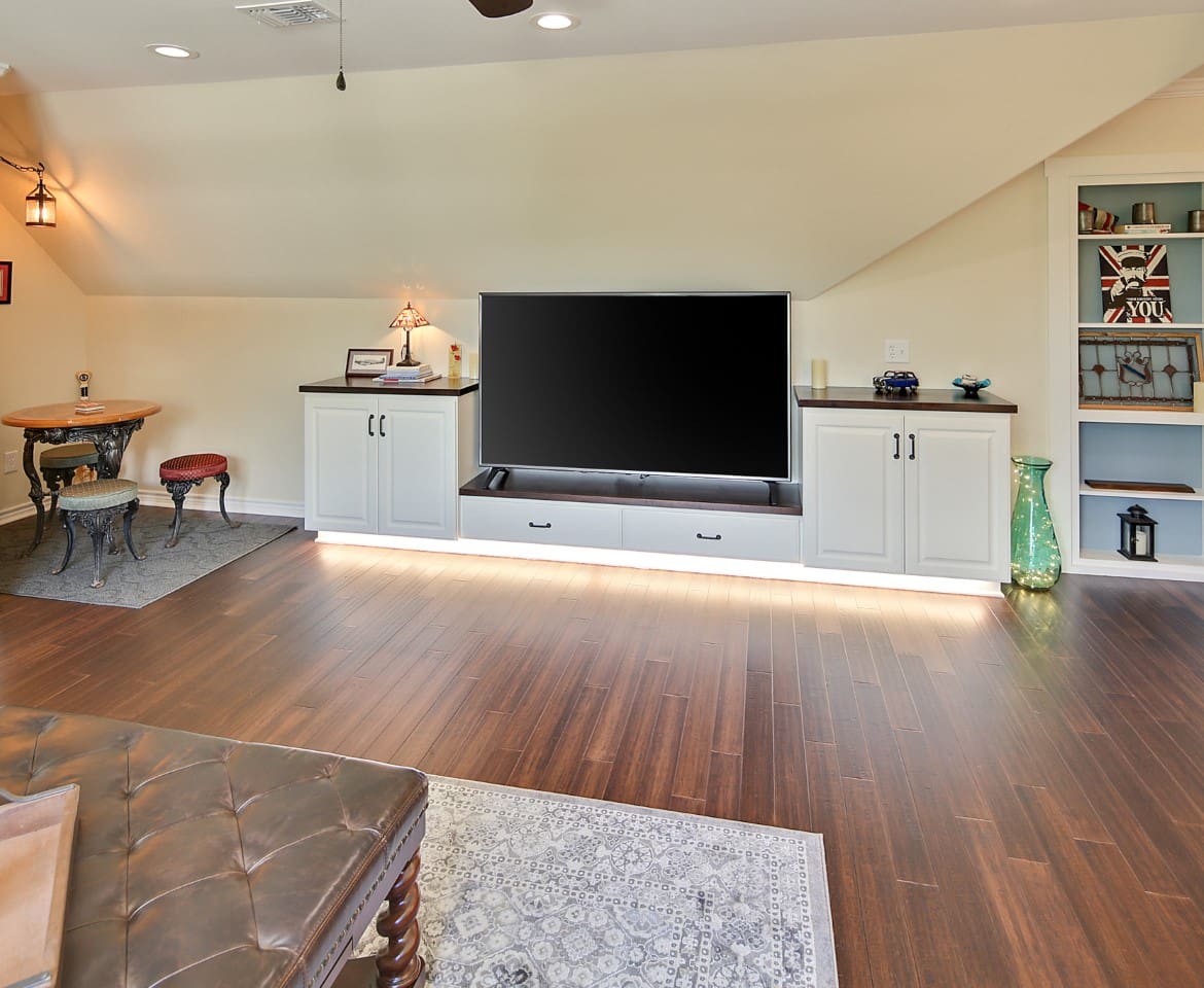 A large flat screen tv sitting on top of a wooden floor.