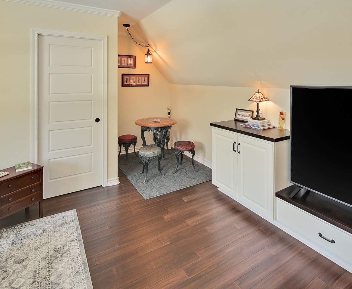 A room with a tv, table and chairs.