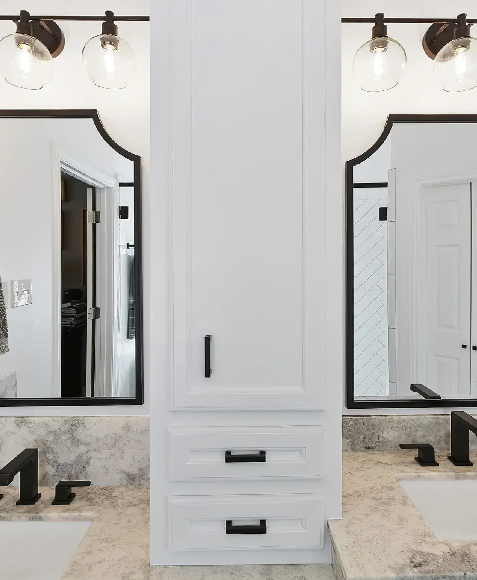 A bathroom with two mirrors and a white cabinet.