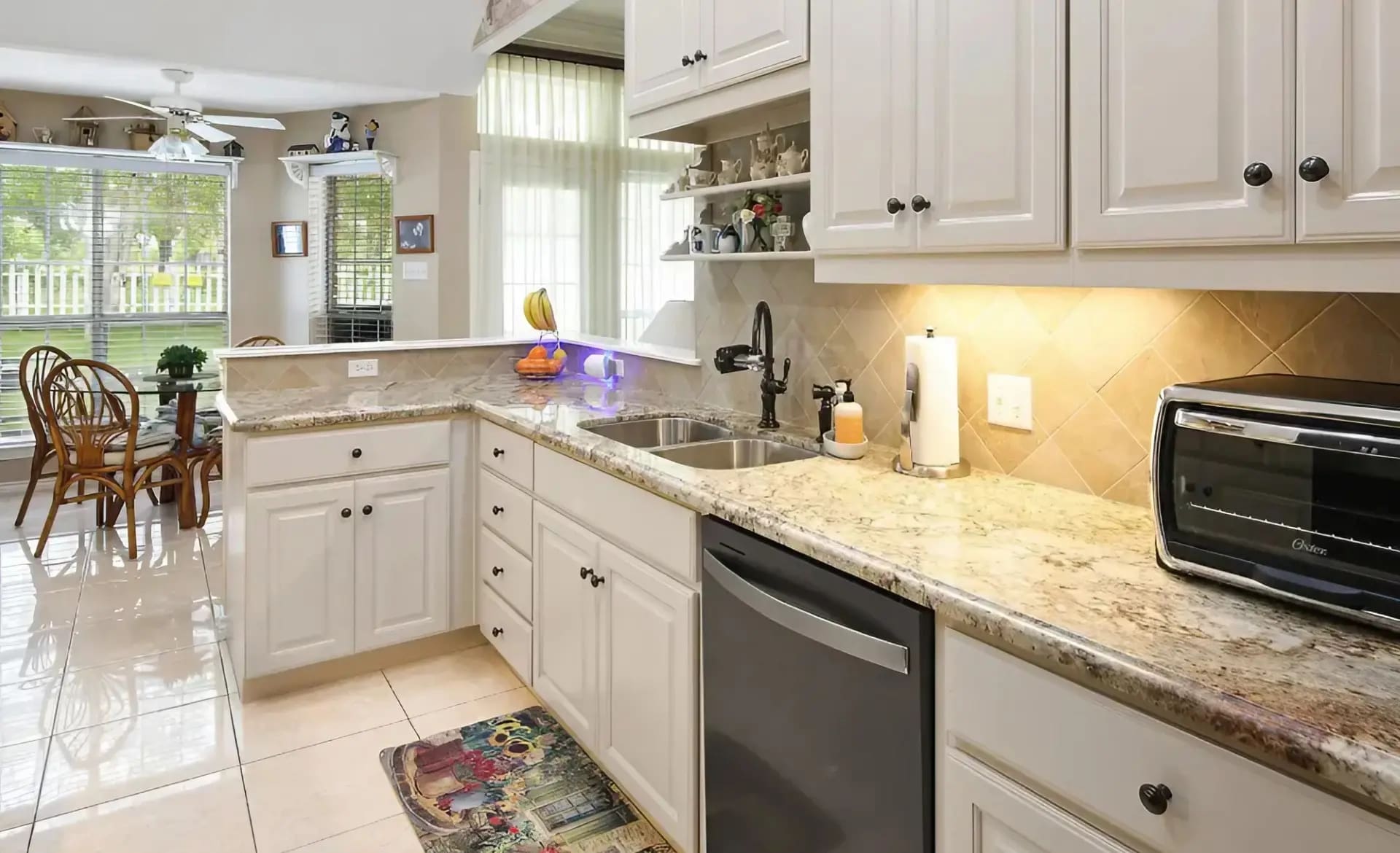 A kitchen with white cabinets and granite counter tops.