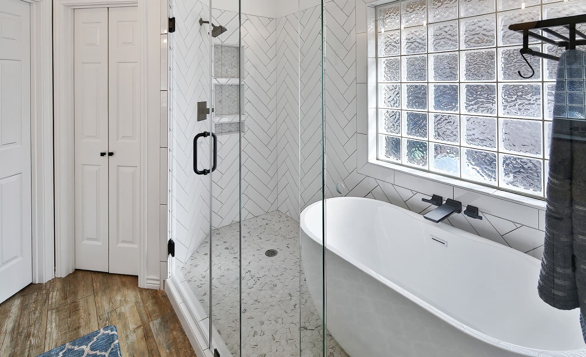 A bathroom with a tub, shower and window.