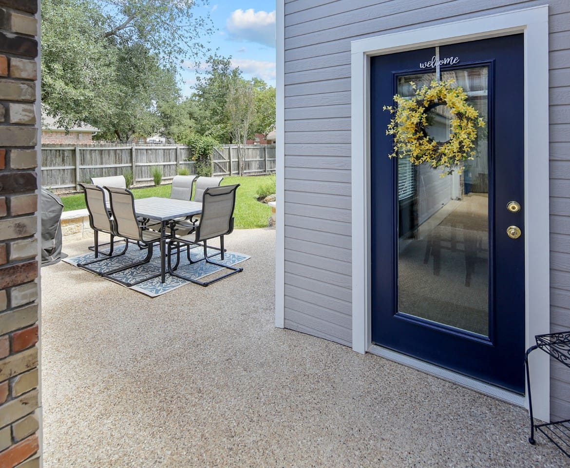 A patio with chairs and table outside of the house