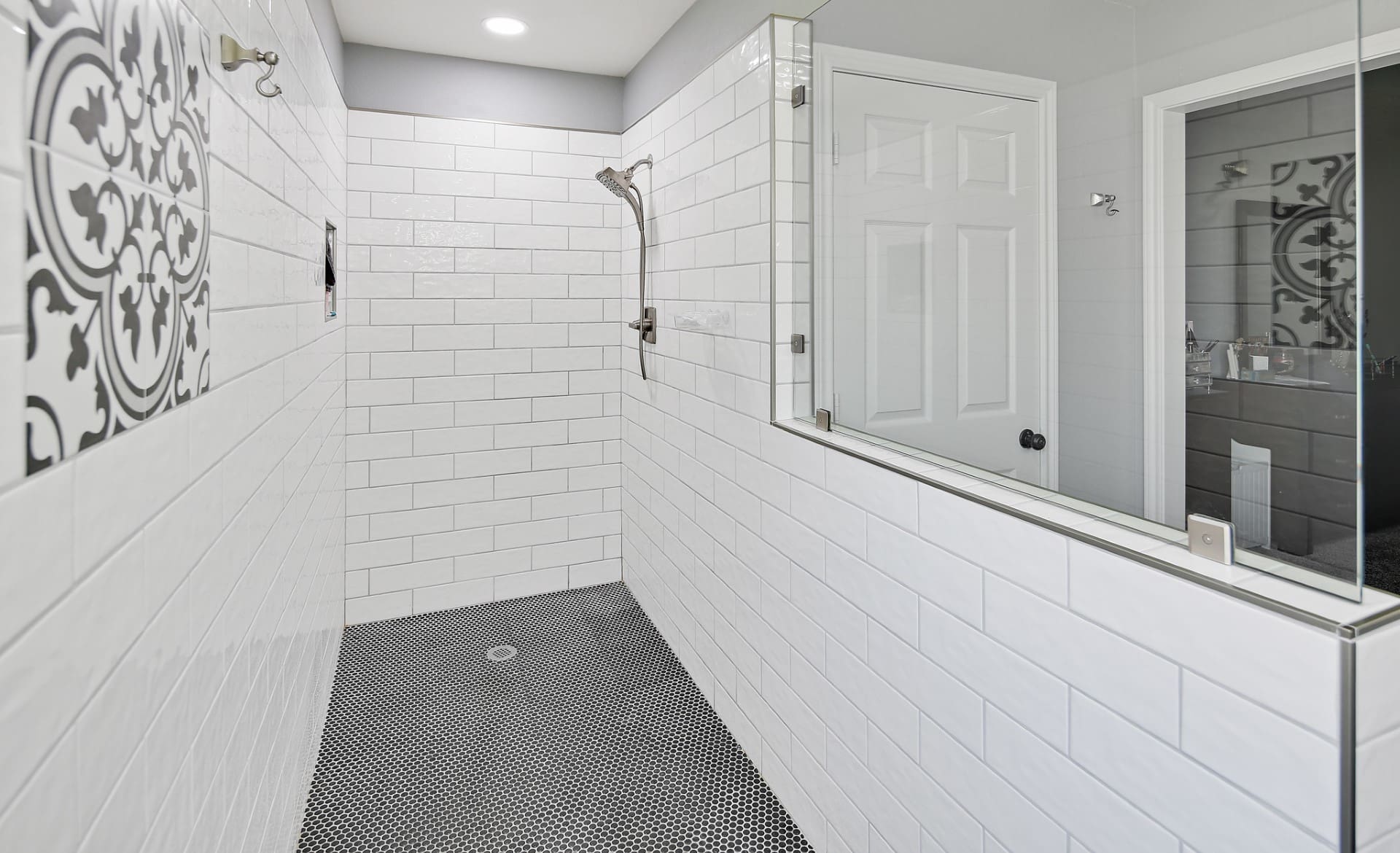 A bathroom with white brick walls and black tile floor.