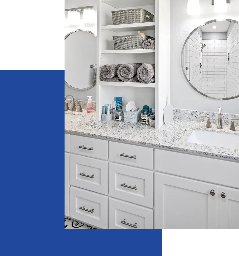 A bathroom with white cabinets and green walls.