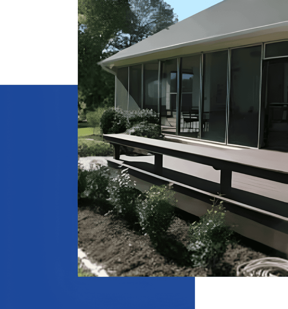 A house with a deck and bushes in the yard.